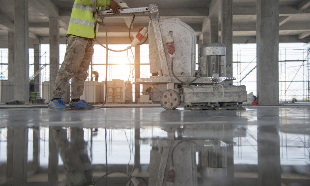 Construction worker produces the grout and finish wet concrete with a special tool. Float blades. For smoothing and polishing concrete, concrete floors